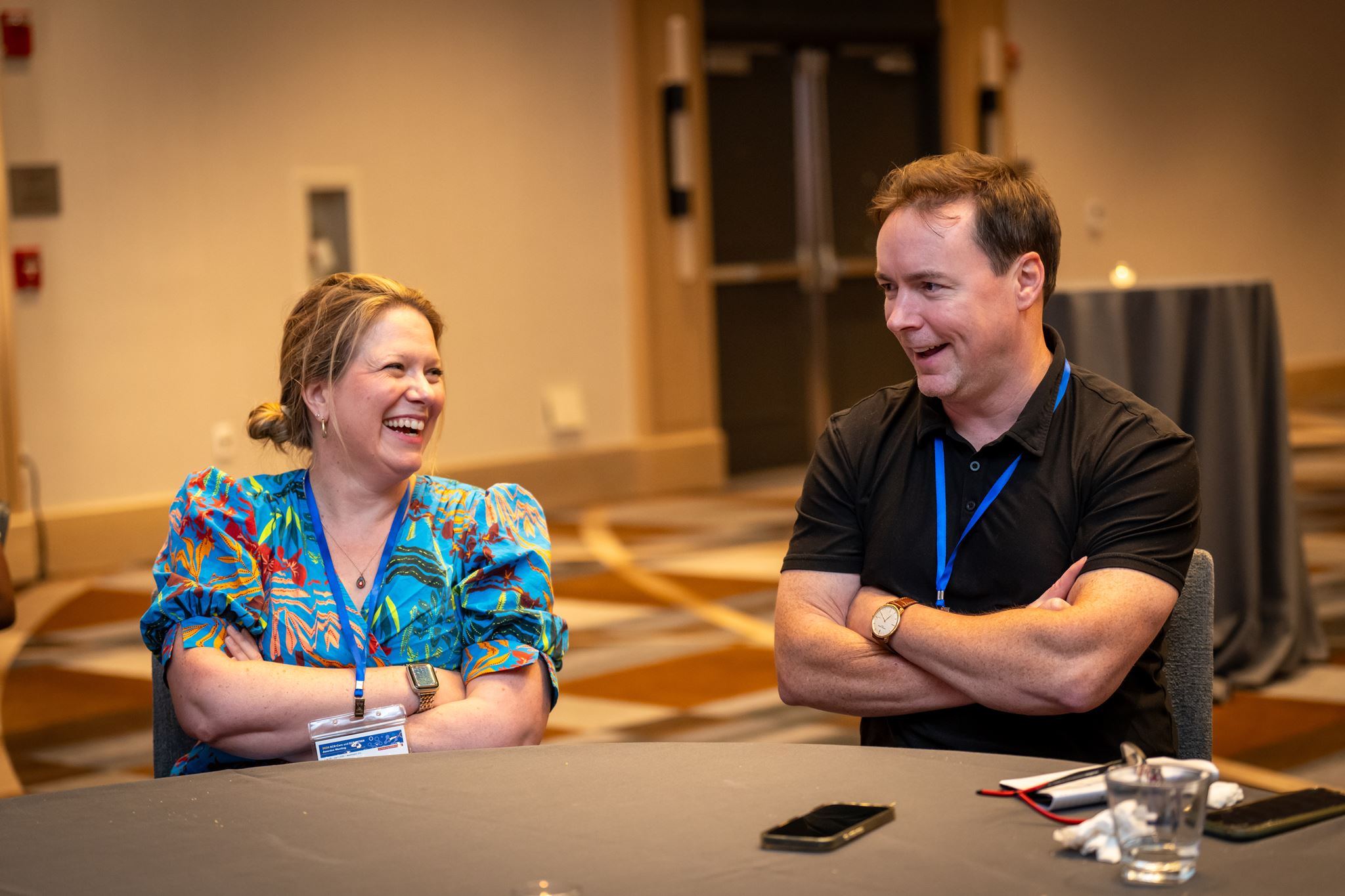 A man and a woman laughing at a table.