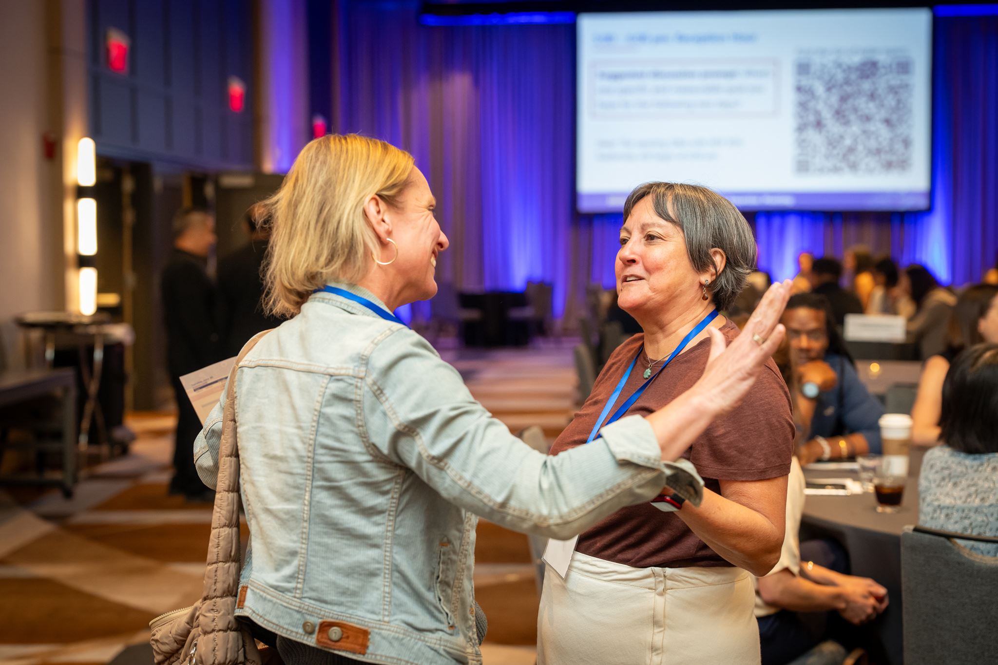 Two women talking to each other at the meeting during break. 