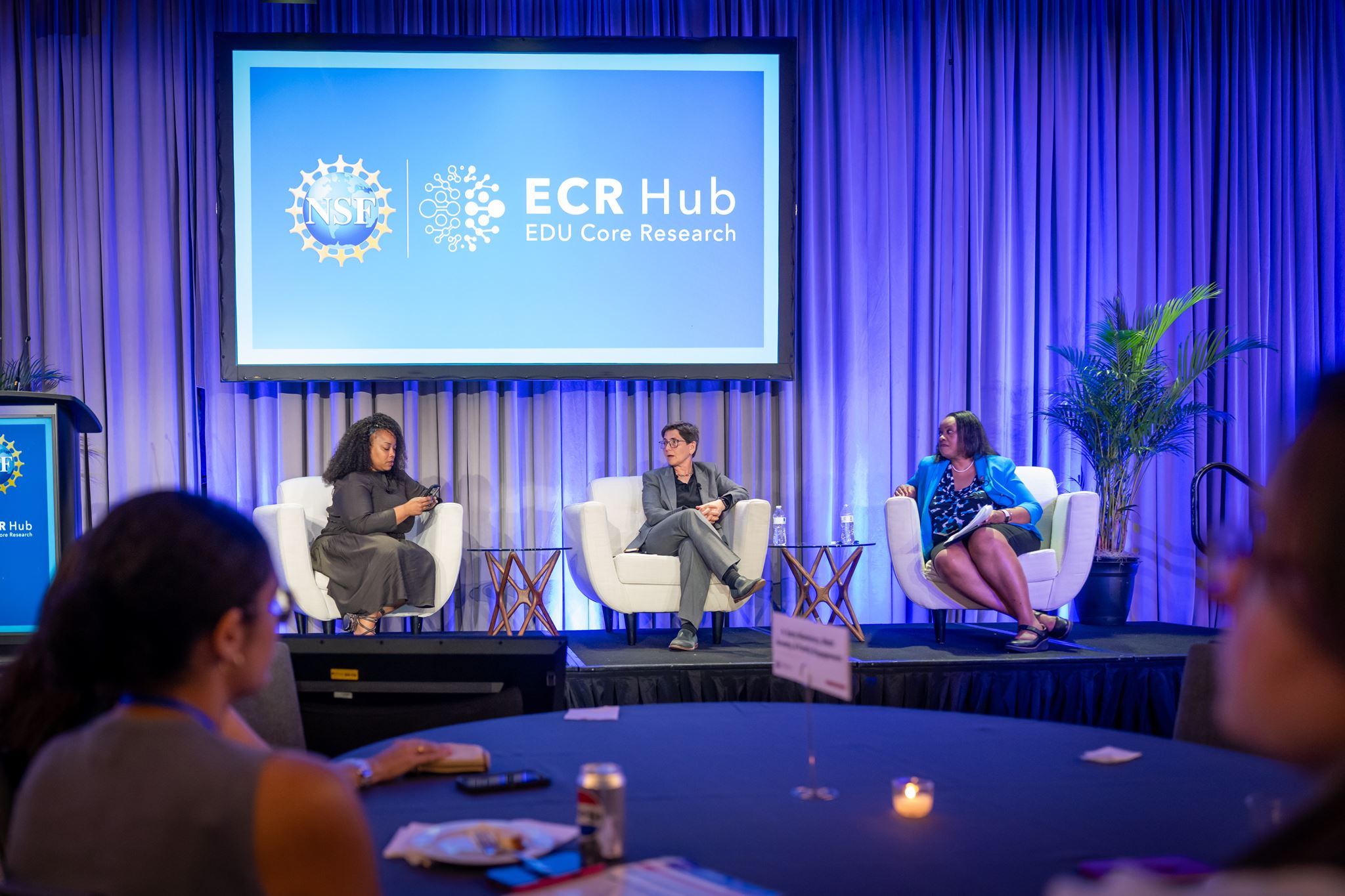 Three women sitting on chairs in front of the session.