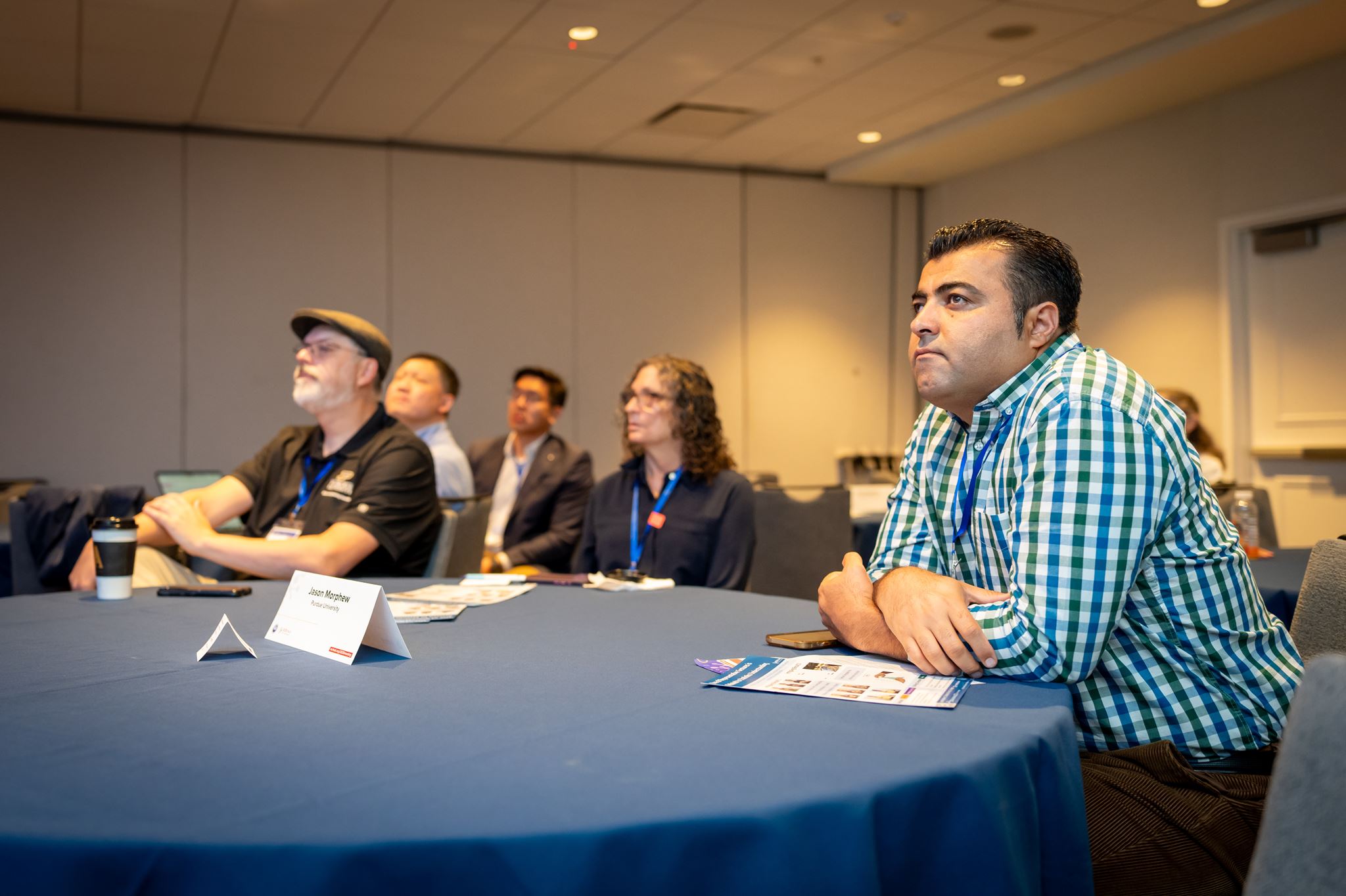 Two men and a woman at table during session. 